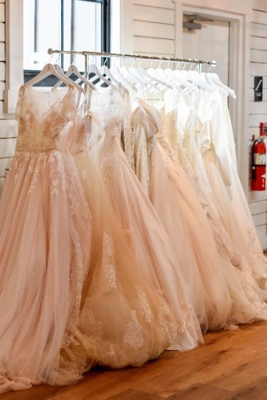A rack of wedding dresses hanging in a row