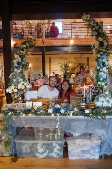 A couple sitting behind a decorated table at an event